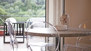 Een helder uitzicht op een balkon met een tafel, stoelen, een rieten mand en een glazen pot met deksel.