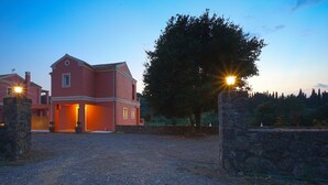 Een gebouw met twee verdiepingen, een grindpad en stenen muren.