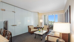 A hotel room with a large bed, a sitting area with two chairs and a table, a TV, and a window with blinds. - Longboat Key Club!! Direct Beachfront!! (Longboat Key)