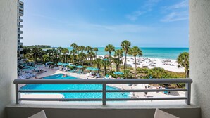 A resort balcony with a pool, beach, and palm trees. - Longboat Key Club!! Direct Beachfront!! (Longboat Key)