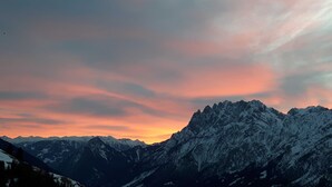 A mountainous landscape with snow-covered peaks and a sunset sky. - Wohnung Ost - Haus Lukasser (Kosten)