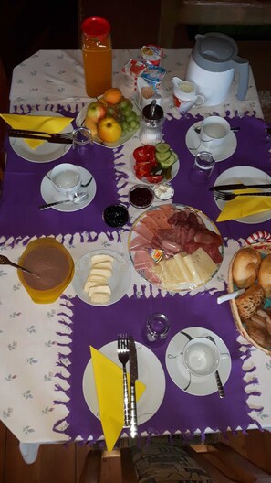 A table set with various food items and utensils, including plates, bowls, and a pitcher. - Wohnung Ost - Haus Lukasser (Kosten)