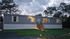 A two-story house with a front porch, a staircase, and a well-maintained lawn. - MANATEE WATCH DEN 1 BEDROOM PET FRIENDLY (Crystal River)