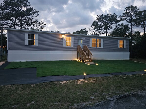 A two-story house with a front porch, a staircase, and a well-maintained lawn. - MANATEE WATCH DEN 1 BEDROOM PET FRIENDLY (Crystal River)
