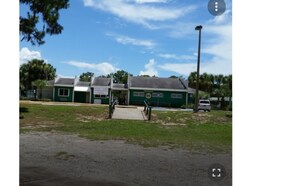 A two-story building with a green facade and a covered entrance. - MANATEE WATCH DEN 1 BEDROOM PET FRIENDLY (Crystal River)