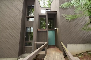 Un bâtiment en bois doté de nombreuses fenêtres et d’une porte.
