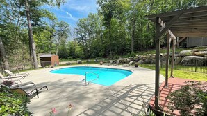A swimming pool with lounge chairs, a covered area, and a small shed in a wooded backyard. - Spacious Kearsarge Woods Unit w Association Pool & Tennis 2 Mins to Downtown (North Conway)