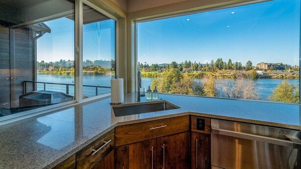 Une cuisine moderne dotée d’une grande fenêtre offrant une vue panoramique sur la rivière.