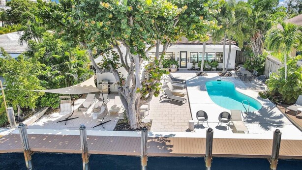 A pool area with lounge chairs, a hot tub, and a pergola. - Beautiful Waterfront Condo on Canal with Pool & Walk to Beach! Boat Watch! 2b/2b (Pompano Beach)