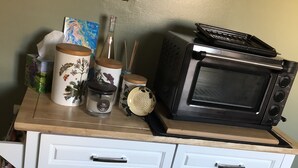 Un plan de travail de cuisine avec un four à micro-ondes, un grille-pain et divers ustensiles de cuisine.