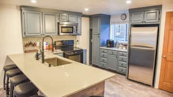 Un four, surface de cuisson, lave-vaisselle, cafetière-théière