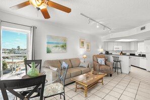 A modern living room with a sofa, chairs, a coffee table, and artwork on the walls. - 🌿 Select View Condo — Gulf Strand Resort, St. Pete Beach (St Pete Beach)