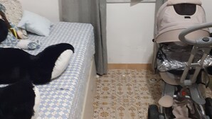 Ett sovrum med en säng, en barnvagn och en stor gosedjur.