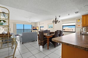 Une cuisine spacieuse avec un coin repas, de grandes fenêtres et un balcon.
