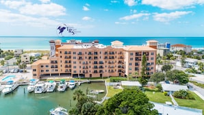 Ein Resort mit mehreren Gebäuden, einer Marina voller Boote und freiem Blick auf den Ozean.
