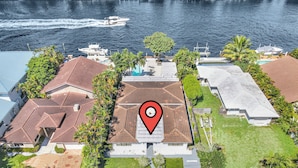 An aerial view of a residential area with multiple houses, a swimming pool, and a marina with boats. - Beautiful Waterfront Condo on Canal with Pool & Walk to Beach! Boat Watch! 1b/1b (Pompano Beach)