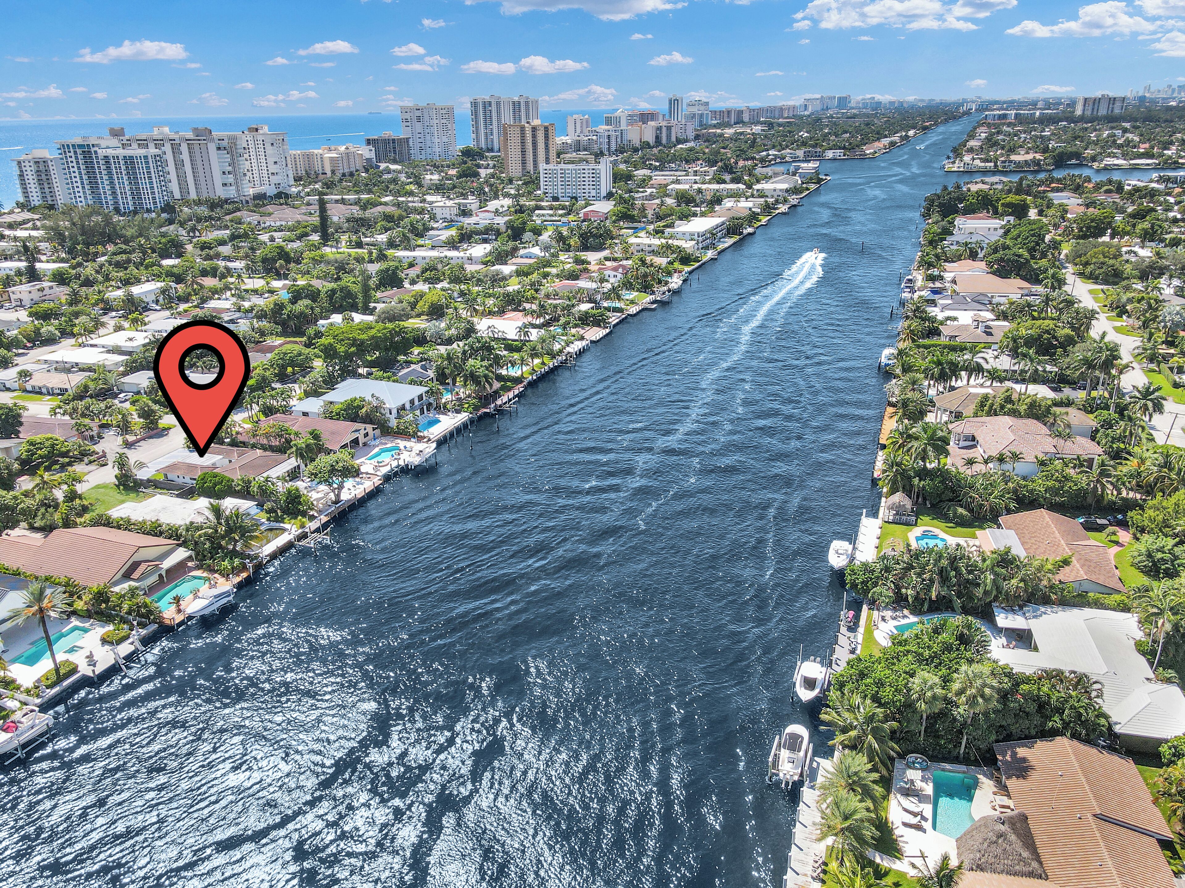 A river running through a residential area with houses and a marina.
