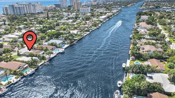 A river running through a residential area with houses and a marina.