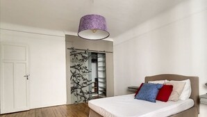 Un dormitorio con cama, armario e iluminación colgante.