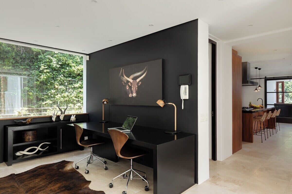 A modern office space with a desk, chair, and a large window.
