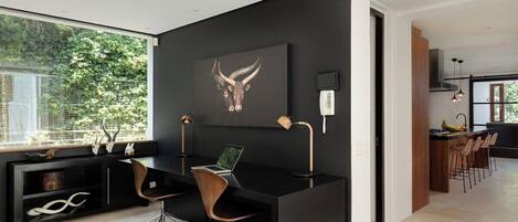 A modern office space with a desk, chair, and a large window.