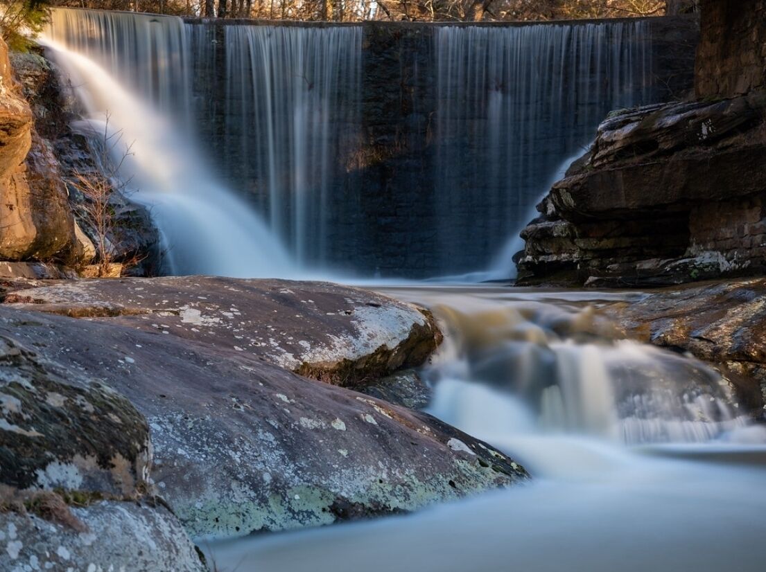Ein Wasserfall stürzt über Felsen, mit freier Sicht auf den Wasserlauf.