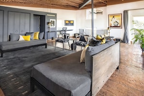 Ein modernes Wohnzimmer mit einer Couch, Sesseln und einem Essbereich.