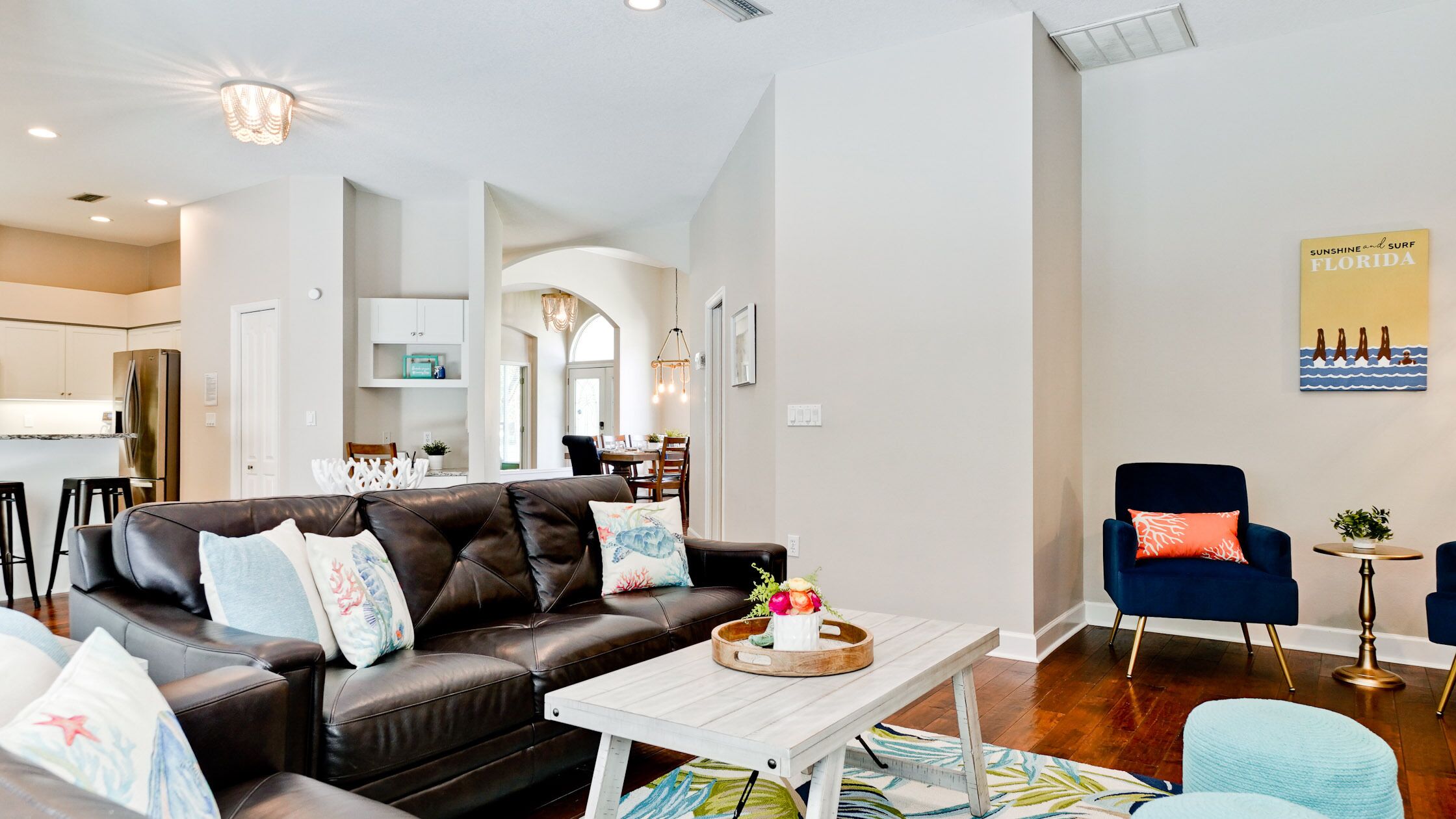 A modern living room with a leather sofa, a wooden coffee table, and a blue armchair.