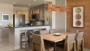 Une cuisine moderne avec des meubles en bois, un réfrigérateur en acier inoxydable et un four à micro-ondes encastré.