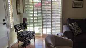 Una sala de estar con una silla estampada con motivos de cebra, un sofá y una mesita.