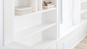Una estantería empotrada blanca con objetos decorativos y libros.