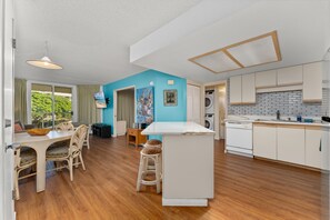 Enjoy meals and relaxation in this spacious living area with a dining table, bar, and comfortable seating.