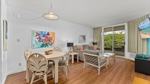 Ein geräumiges Wohnzimmer mit Essbereich, einer Couch und einem Fernseher.