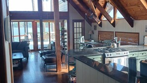 Una cocina amplia con una isla grande, vigas de madera y vistas al exterior.