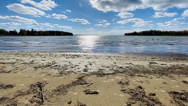 Ein Strand mit klarem Himmel und ruhigem Wasser.