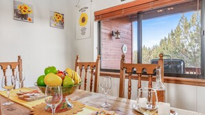 Een eettafel gedekt met een fruitschaal, kaasplank, wijnglazen en een kaars.