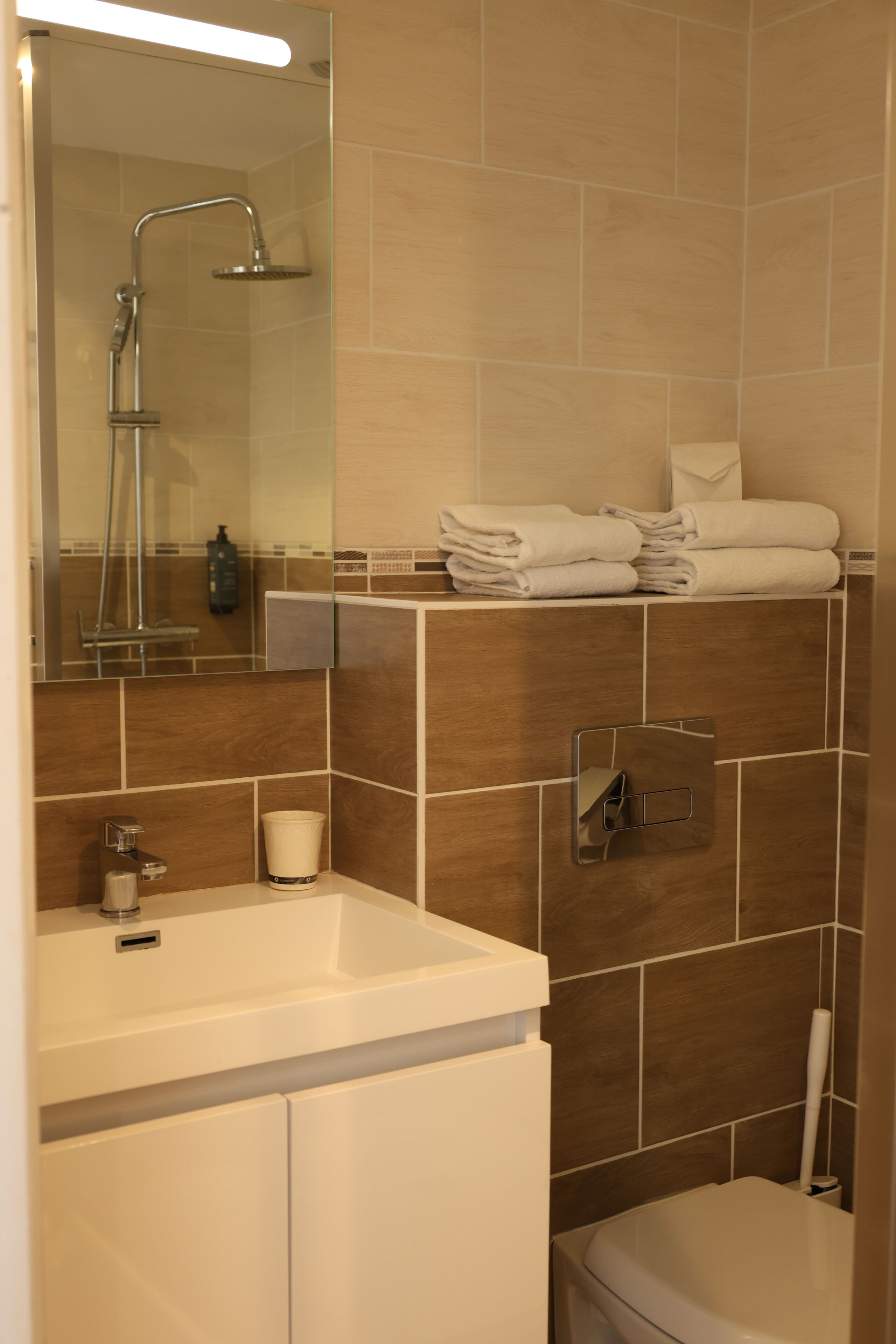 Une salle de bain moderne équipée d’une douche, de toilettes et d’un lavabo.