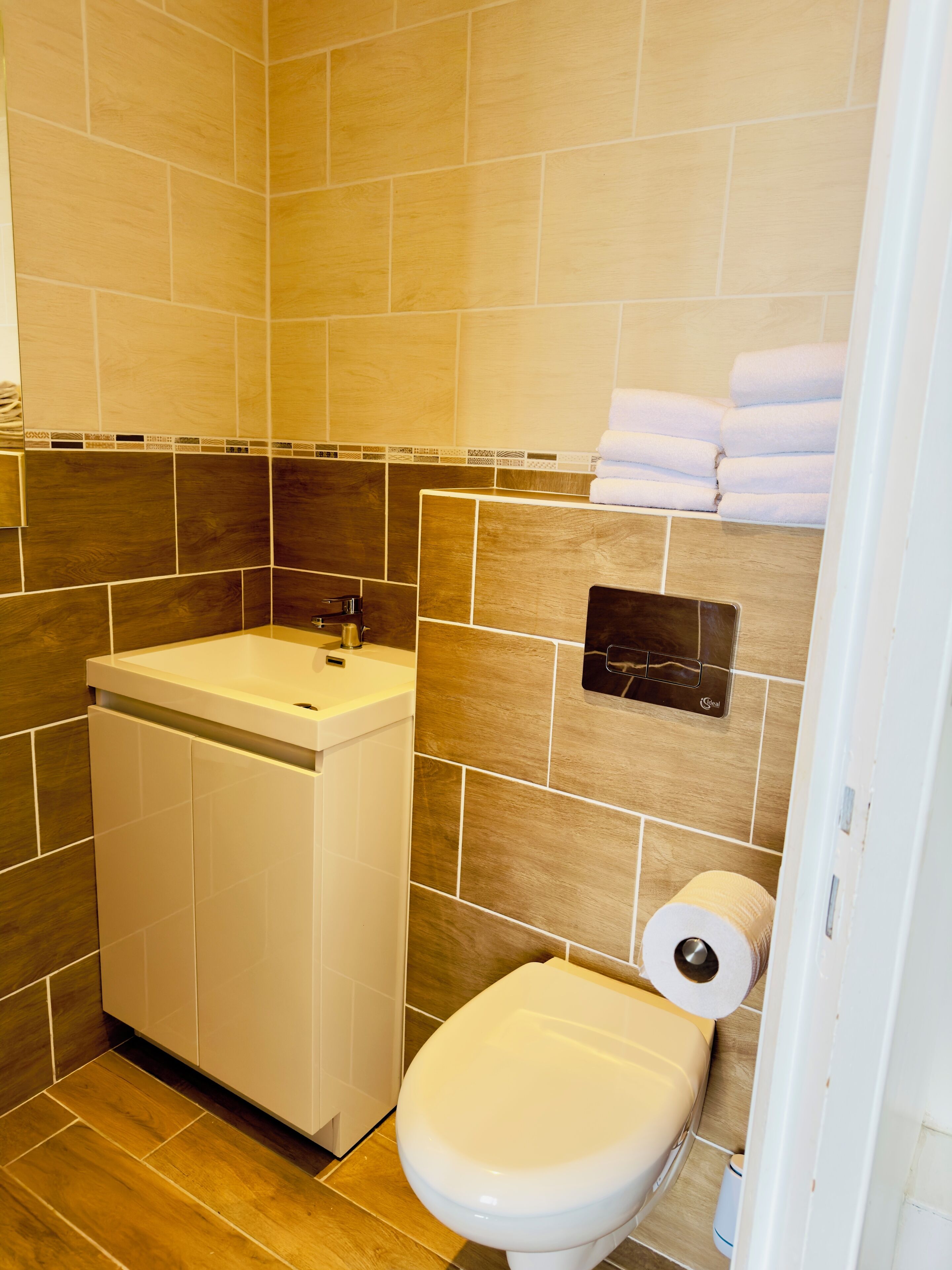 Un baño con lavabo, inodoro y toallero.