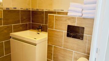 A bathroom with a sink, toilet, and towel rack.