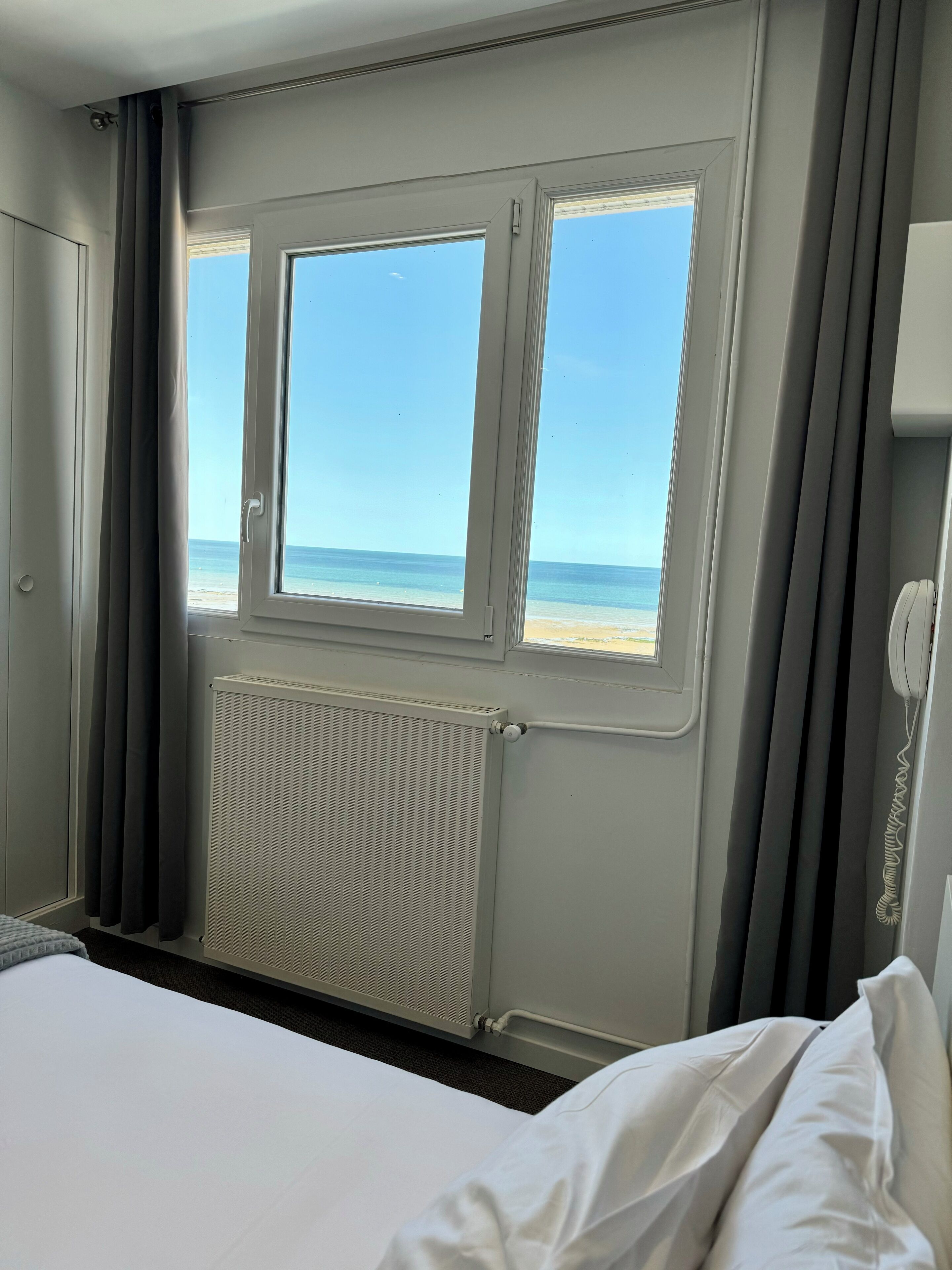 Camera d'albergo con un'ampia finestra vista spiaggia.