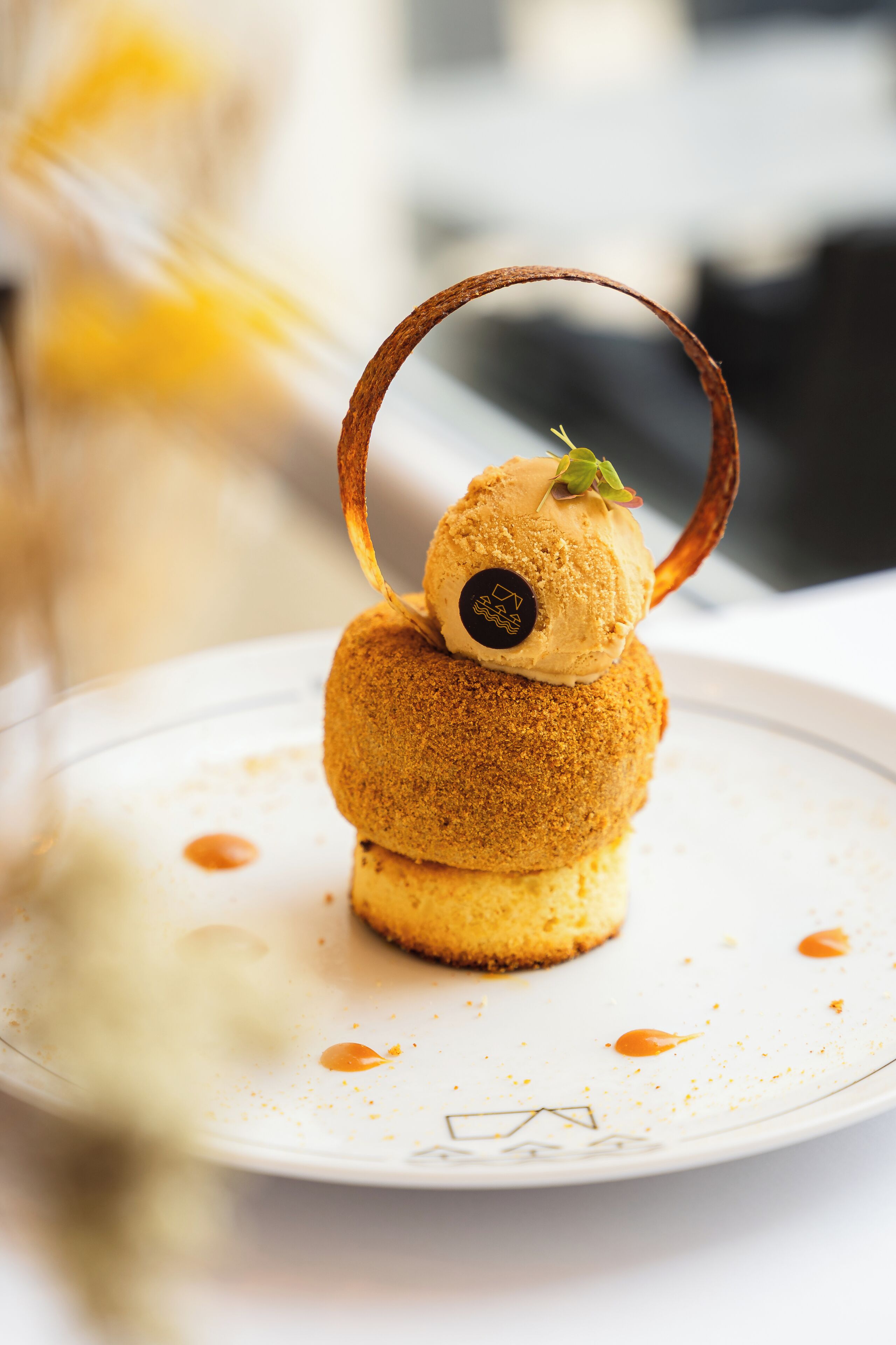 A dessert on a plate with a decorative metal ring.
