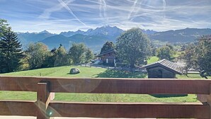 A wooden deck overlooking a mountainous landscape with a clear sky. - Luxurious Duplex Chalet Apartment with Stunning Mont Blanc View (Combloux)