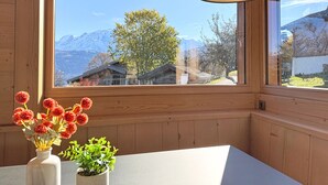 A wooden interior with a large window offering a mountain view. - Luxurious Duplex Chalet Apartment with Stunning Mont Blanc View (Combloux)