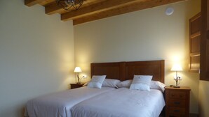 Un lit double avec une tête de lit en bois, deux tables de chevet avec des lampes et un plancher en bois.