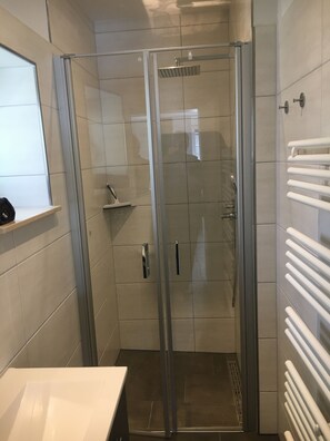 Regadera, secadora de cabello, toallas, papel de baño 