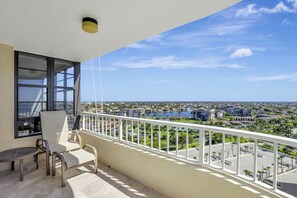 A balcony with a view of a cityscape and a body of water.