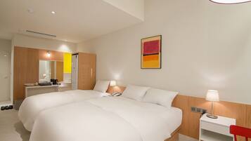 Habitación de hotel con una cama grande, mesitas de noche, un escritorio y un espejo.