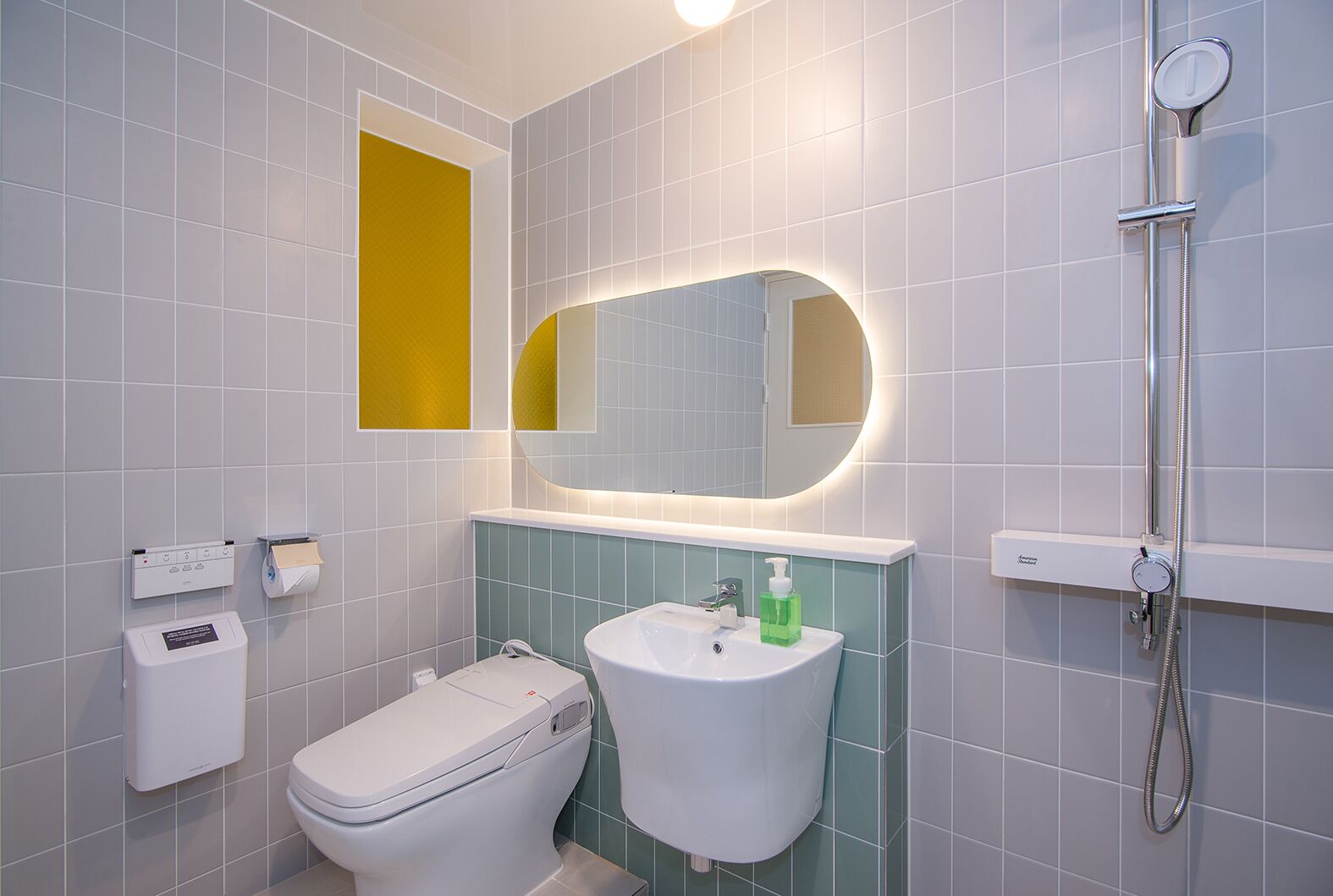 A modern bathroom with a toilet, sink, and shower.