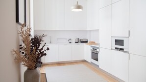 Eine moderne Küche mit weißen Schränken, einer Holz Arbeitsplatte und einer hängenden Pendelleuchte.