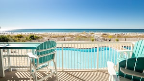 A balcony with a pool and chairs overlooking a beach. - WHERE THE GULF MEETS YOUR LIVING ROOM! (Ft Walton Beach)